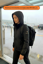 Woman wearing Travhalór waterproof wearable suitcase by the airport in rainy weather
